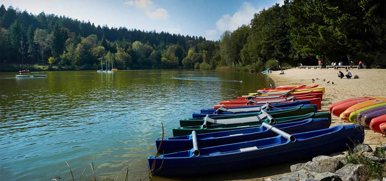 Brightly coloured kayaks line the edge of the lake