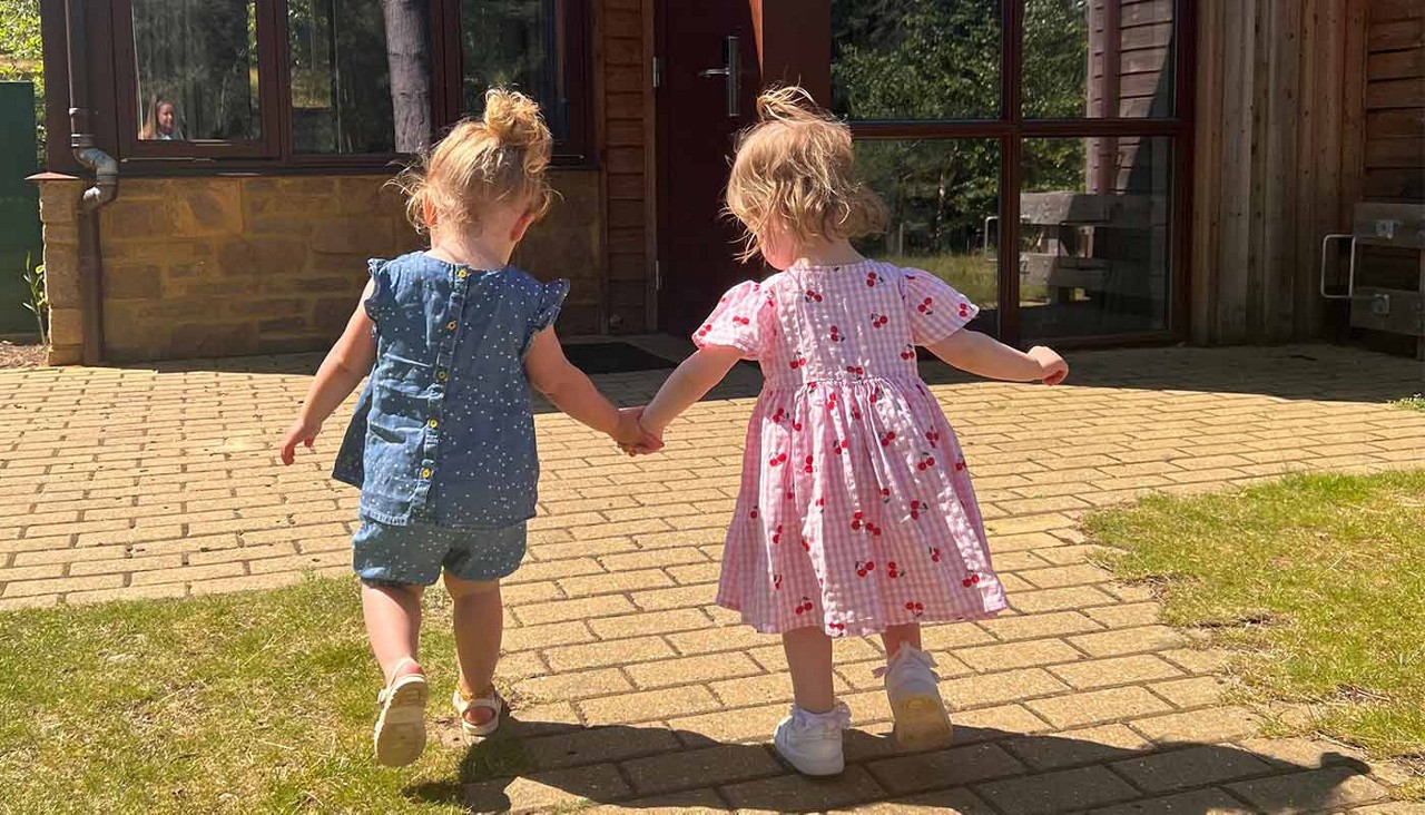 2 girls holding hands outside of the lodge