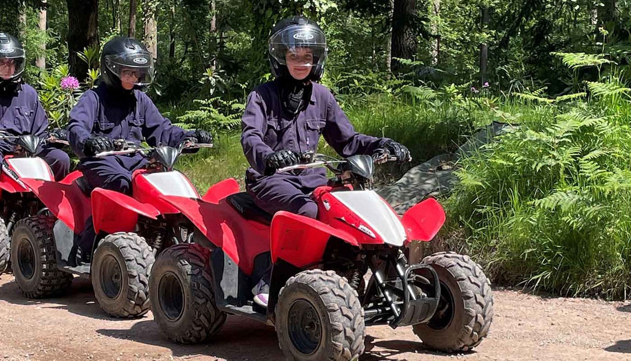 Three guests riding on quad bikes 
