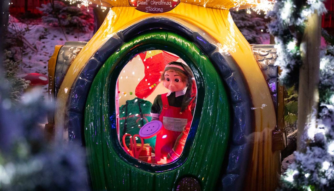 A festive toadstool cabin with an elf inside.