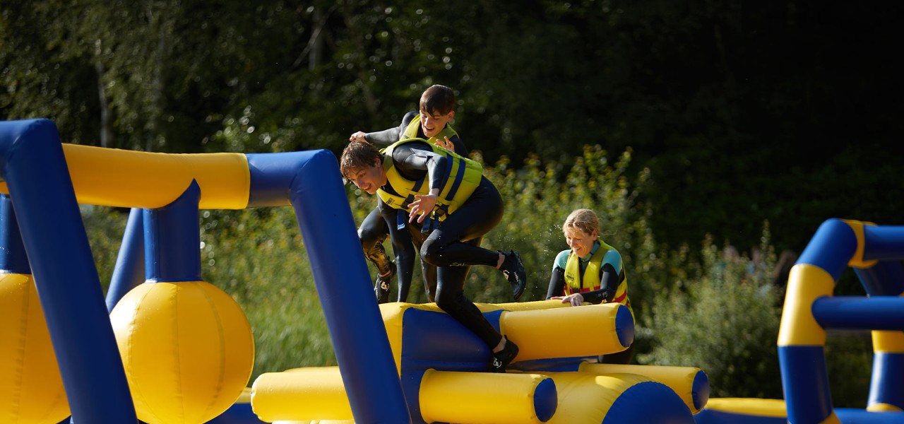 A family on the aqua parc inflatable obstacle course.